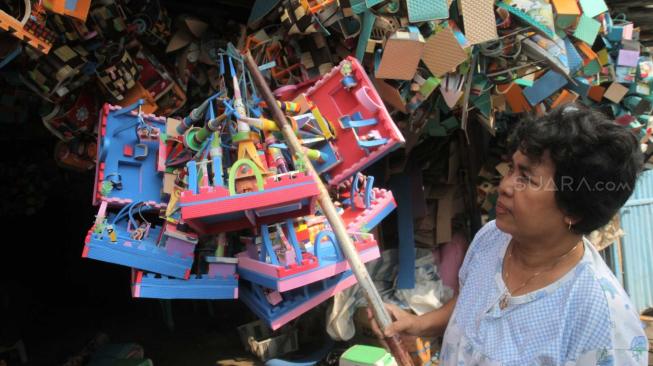 Penjual menyusun rumah mainan dari limbah Karet Spon untuk dijual di Bekasi, Jawa Barat, Selasa (27/11). (Suara.com/Fakhri Hermansyah)