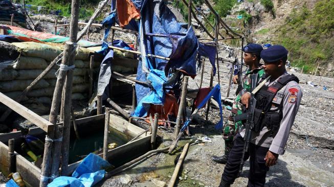 Personel kepolisian dan TNI berjaga di tempat penambangan emas ilegal yang ditutup di Gunung Botak, Pulau Buru, Maluku, Rabu (28/11). ANTARA FOTO/Rivan Awal Lingga