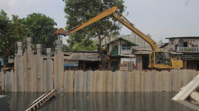 Pekerja menyelesaikan pemasangan dinding turap di kali Sention, Kemayoran, Jakarta pusat, Rabu (28/11). (Suara.com/Fakhri Hermansyah)