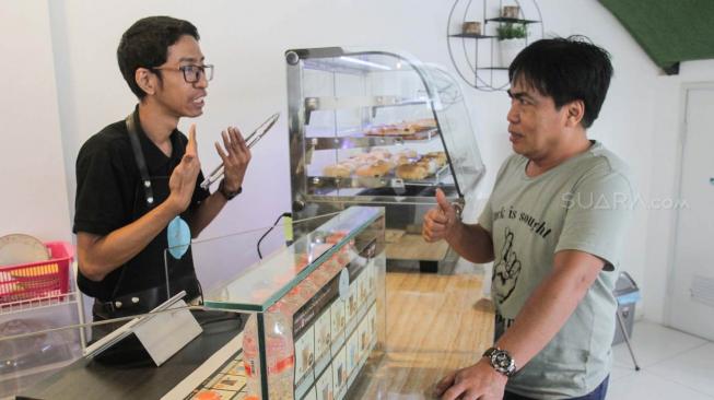 Pelayanan Cafe Koptul (Kopi Tuli) menggunakan bahasa isyarat di kawasan Duren Tiga, Pancoran, Jakarta Selatan, Kamis (29/11). (Suara.com/Fakhri Hermansyah)