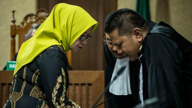 Terdakwa kasus suap PLTU Riau-1 Eni Maulani Saragih (kiri) berbincang dengan kuasa hukumnya saat mengikuti sidang dakwaan, di Pengadilan Tipikor, Jakarta, Kamis (29/11). ANTARA FOTO/Aprillio Akbar