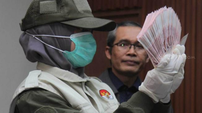 Wakil Ketua Alexander Marwata bersama penyidik KPK menunjukkan barang bukti uang pada konferensi pers OTT Hakim dan pegawai di Pengadilan Negeri (PN) Selatan oleh KPK, di Kuningan, Jakarta Selatan, Rabu (28/11). (Suara.com/Fakhri Hermansyah)