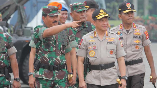 Panglima TNI Marsekal  Hadi Tjahjanto bersama Kapolri Jenderal Tito Karnavian meriksa pasukan saat apel  pengamanan Natal, Tahun Baru, Pileg dan Pilpres 2019 di Monas, Jumat (30/11). (Suara.com/Fakhri Hermansyah)