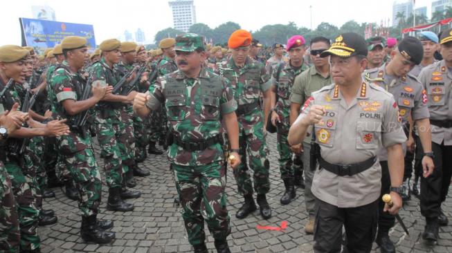 Panglima TNI Marsekal  Hadi Tjahjanto bersama Kapolri Jenderal Tito Karnavian meriksa pasukan saat apel  pengamanan Natal, Tahun Baru, Pileg dan Pilpres 2019 di Monas, Jumat (30/11). (Suara.com/Fakhri Hermansyah)