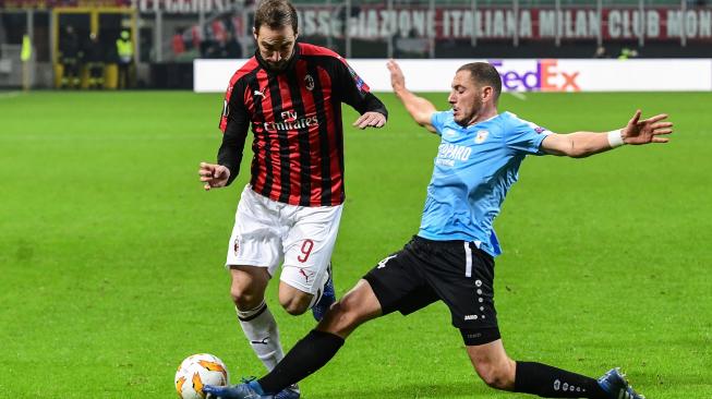 Gelandang Dudelange Clement Couturier menghadang pemain depan AC Milan Gonzalo Higuain, selama pertandingan Grup F Liga Europa antara AC Milan melawan Dudelange di Stadion San Siro, Milan, Italia, Jumat (30/11). [Miguel MEDINA / AFP]