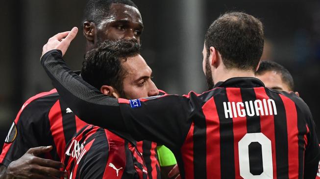 Gelandang AC Milan Hakan Calhanoglu merayakan golnya bersama Gonzalo Higuain dan Cristian Zapata, selama pertandingan Grup F Liga Europa antara AC Milan melawan Dudelange di Stadion San Siro, Milan, Italia, Jumat (30/11). .[Miguel MEDINA / AFP]