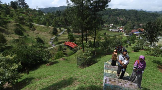 Seorang warga berkunjung di Kawasan Wisata Cikaret Pongkor, kabupaten Bogor, Jawa Barat, Jumat (30/11). [Suara.com/Muhaimin A Untung]