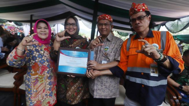 GM Unit Bisnis Pertambangan Emas ANTAM Made Mastana (kanan), Direktur Operasi ANTAM Hari Widjajanto (kedua kanan), Bupati Bogor Nurhayati (kiri)  dan Ade Yasin memperlihatkan sertifikat Pongkor sebagai Geopark Nasional saat penyerahan sertifikat Geopark Nasional di Desa Cisarua, Kabupaten Bogor, Jumat (30/11). [Suara.com/Muhaimin A Untung