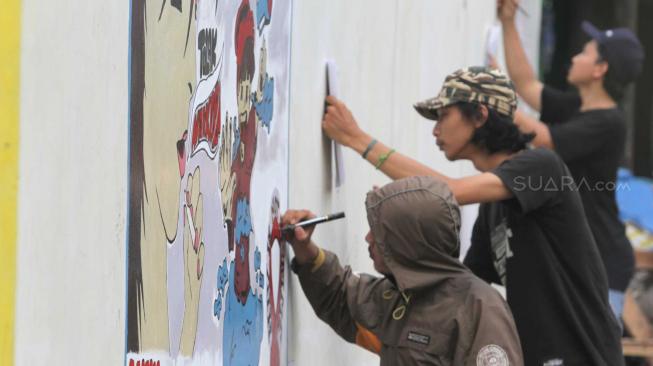 Sejumlah anak muda mengikuti lomba mural  dalam rangka memperingati Hari AIDS sedunia di Rawalumbu , Bekasi, Jawa Barat, Sabtu (1/12).  (Suara.com/Fakhri Hermansyah)