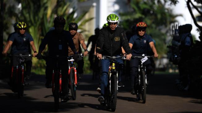 Presiden Joko Widodo bersepeda menuju lokasi penyambungan instalasi listrik PLN gratis melalui sinergi BUMN untuk masyarakat di Bogor, Jawa Barat, Minggu (2/12/2018). ANTARA FOTO/Wahyu Putro A