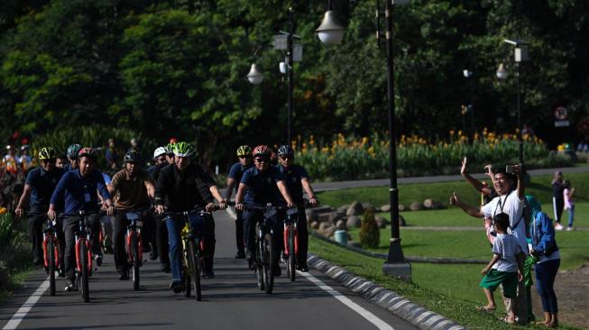 Presiden Joko Widodo bersepeda menuju lokasi penyambungan instalasi listrik PLN gratis melalui sinergi BUMN untuk masyarakat di Bogor, Jawa Barat, Minggu (2/12/2018). ANTARA FOTO/Wahyu Putro A