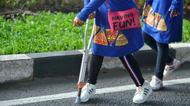 Sejumlah penyandang disabilitas fisik mengikuti jalan sehat bersama insan disabilitas di Surabaya, Jawa Timur, Minggu (2/12). ANTARA FOTO/M Risyal Hidayat