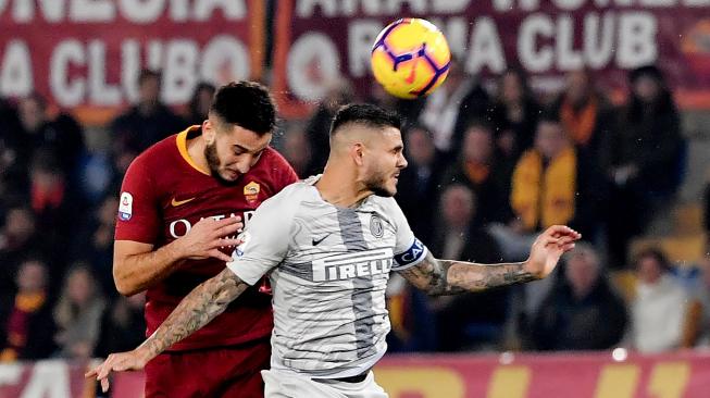 Penyerang Inter Milan Mauro Icardi bertarung untuk memperebutkan bola dengan pemain AS Roma Konstantinos Manolas saat pertandingan sepak bola Serie A Italia antara AS Roma melawan Inter Milan di stadion Olimpico, Roma, Italia, Senin (3/12). [Tiziana FABI / AFP]