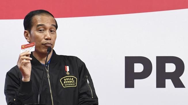 Presiden Joko Widodo menunjukkan kartu Program Keluarga Harapan (PKH) saat sosialisasi kepada penerima dan pendamping di Gelanggang Remaja Jakarta Timur, Jakarta, Senin (3/12).  [ANTARA FOTO/Puspa Perwitasari]