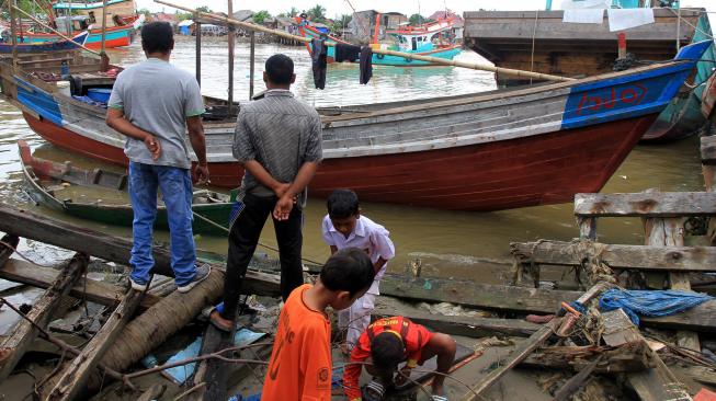 Sejumlah warga melihat perahu milik warga etnis Rohingya yang terdampar di Pelabuhan Kuala Idi Rayeuk, Aceh Timur, Aceh, Selasa (4/12). [ANTARA FOTO/Syifa Yulinnas]