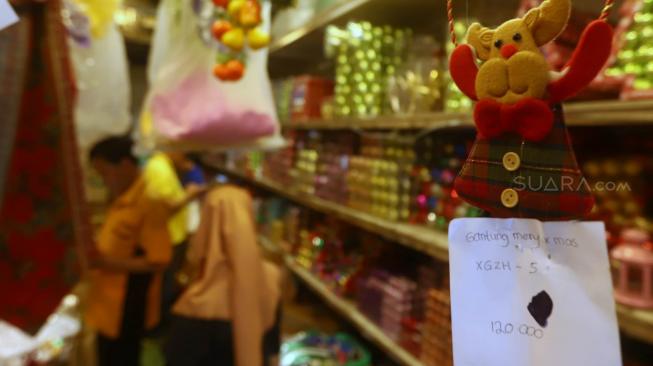 Pembeli memilih pernak-pernik Natal yang dijual di Pasar Asemka, Jakarta, Selasa (4/12). [Suara.com/Muhaimin A Untung]