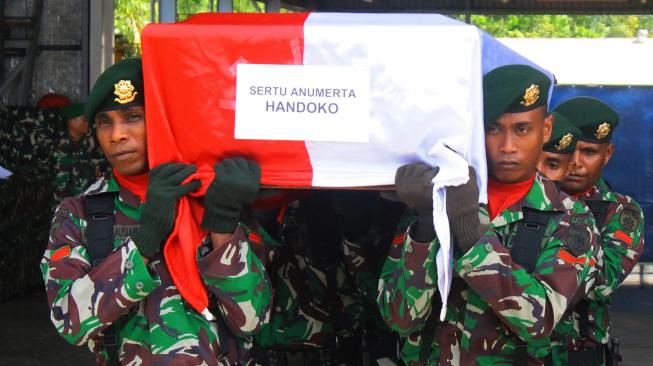 Prajurit TNI memanggul peti berisi jenazah Sertu Anumerta Handoko saat upacara pelepasannya di hanggar Avco Bandara Moses Kilangin Timika, Mimika, Papua, Kamis (6/12).[ANTARA FOTO]