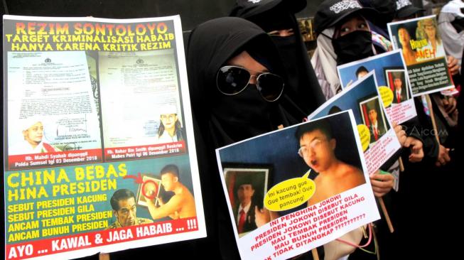 Massa yang tergabung dalam Laskar Pembela Islam (LPI) membawa poster tuntutan saat aksi mengawal pemeriksaan Habib Bahar bin Smith di depan Gedung Bareskrim, Gambir, Jakarta Pusat, Kamis (6/12). [Suara.com/Fakhri Hermansyah]