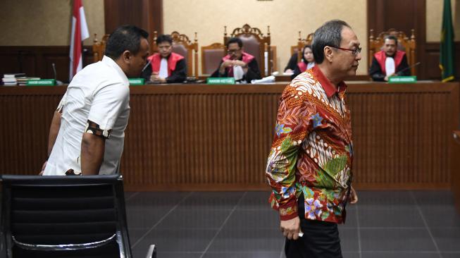 Terdakwa kasus korupsi KTP Elektronik Made Oka Masagung dan Irvanto Hendra Pambudi meninggalkan ruangan seusai menjalani sidang pembacaan putusan di Pengadilan Tipikor, Jakarta, Rabu (5/12). [ANTARA FOTO/Akbar Nugroho Gumay]