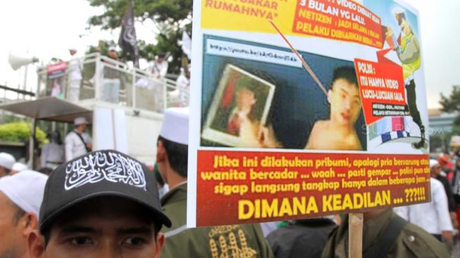 Massa yang tergabung dalam Laskar Pembela Islam (LPI) membawa poster tuntutan saat aksi mengawal pemeriksaan Habib Bahar bin Smith di depan Gedung Bareskrim, Gambir, Jakarta Pusat, Kamis (6/12). [Suara.com/Fakhri Hermansyah]