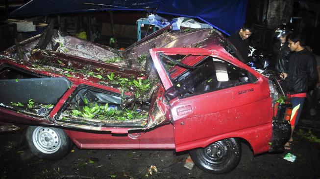 Warga melihat mobil yang hancur akibat tertimpa pohon di kawasan Siliwangi, Batu Tulis, Bogor, Jawa Barat, Kamis (6/12). [ANTARA FOTO/Arif Firmansya]