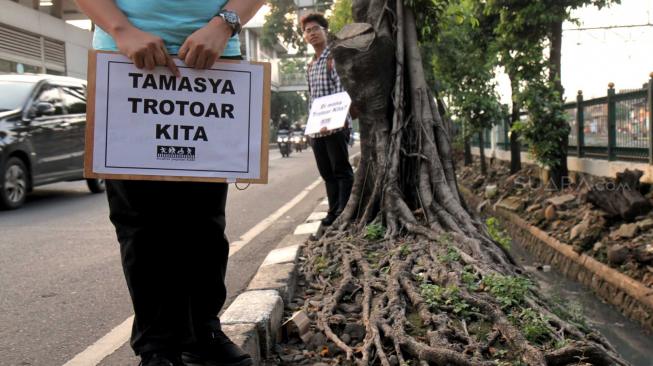 Aktivis Koalisi Pejalan Kaki  melakukan aksi di sepanjang trotoar Jl. I Gusti Ngurah rai,  Jakarta Timur, Jumat (7/12). [Suara.com/Fakhri Hermansyah]