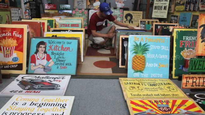 Pengrajin merapikan kerajinan Hand Wood bergaya retro di Pondok Bambu, Jakarta Timur, Sabtu (8/12). [Suara.com/Fakhri Hermansyah]