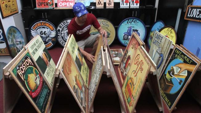 Pengrajin merapikan kerajinan Hand Wood bergaya retro di Pondok Bambu, Jakarta Timur, Sabtu (8/12). [Suara.com/Fakhri Hermansyah]