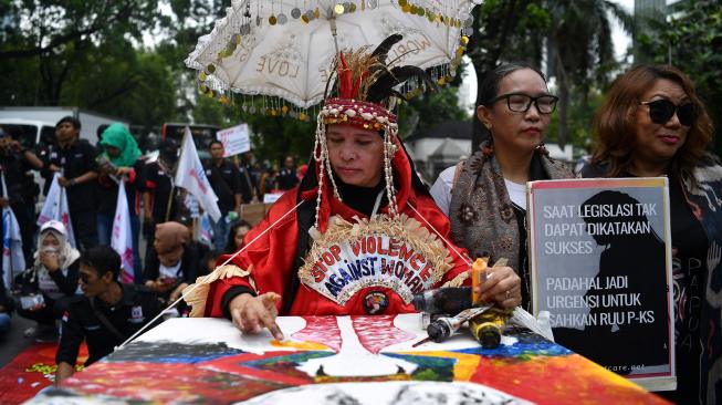 Masyarakat dari berbagai aliansi melakukan aksi damai bertajuk stop kekerasan seksual di Jalan Medan Merdeka Barat, Jakarta, Sabtu (8/12).[ANTARA FOTO/Sigid Kurniawan]