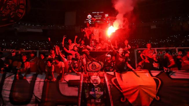 Suporter The Jakmania berselebrasi usai persija keluar sebagai juara Liga 1 di Stadion Utama Gelora Bung Karno, Jakarta, Minggu (9/12). [Suara.com/Muhaimin A Untung]