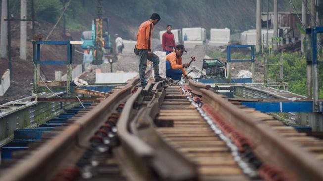 Pekerja memasang bantalan rel pada proyek pengerjaan reaktivasi jalur kereta Cianjur-Padalarang di Ciranjang, Kabupaten Cianjur, Jawa Barat, Senin (10/12). ANTARA FOTO/Raisan Al Farisi