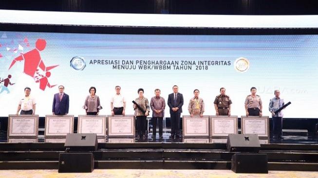 Wakil Presiden Jusuf Kalla didampingi oleh Menteri PAN-RB Syafruddin foto bersama setelah menyerahkan penghargaan zona integritas menuju WBK/WBBM tahun 2018. (Suara.com/ Chyntia Sami)