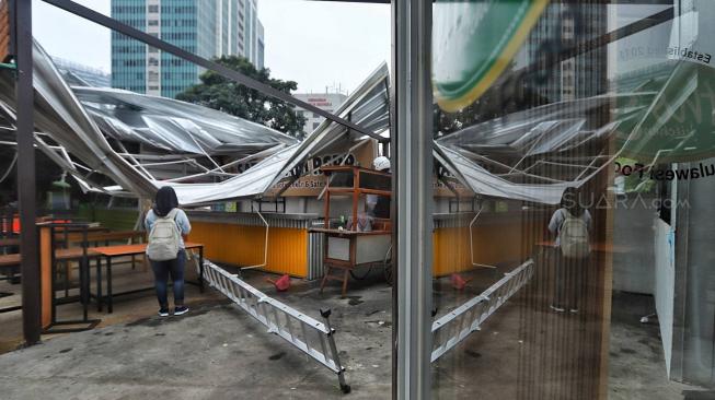 Warga melihat bangunan roboh di Rasuna Garden, Epicentrum Kuningan,  Jakarta, Senin (10/12). [Suara.com/Muhaimin A Untung]