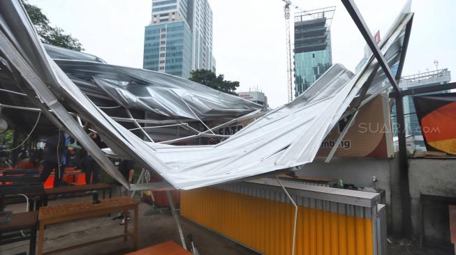 Warga melihat bangunan roboh di Rasuna Garden, Epicentrum Kuningan,  Jakarta, Senin (10/12). [Suara.com/Muhaimin A Untung]