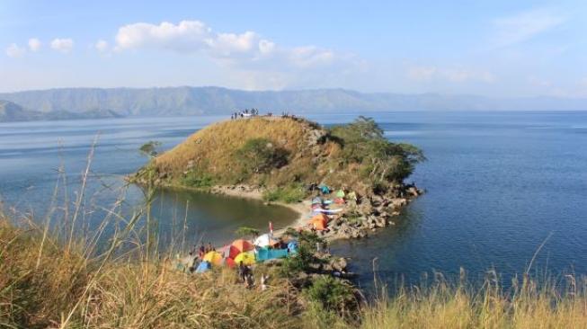 Pemandangan bukit di tengah perairan Danau Toba sekitar Paropo. (Suara.com/Silfa Humairah)