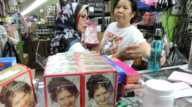 Petugas  gabungan Badan Pengawas Obat dan Makanan (BPOM) bersama Satpol  PP Jakarta  memeriksa kosmetik impor saat inspeksi mendadak di pertokoan Pasar Baru, Jakarta Pusat, Rabu (12/12). [Suara.com/Fakhri Hermansyah]