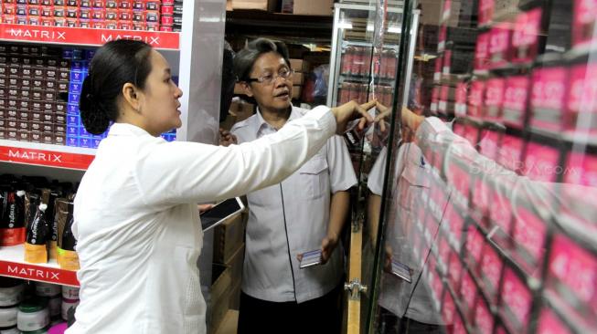 Petugas  gabungan Badan Pengawas Obat dan Makanan (BPOM) bersama Satpol  PP Jakarta  memeriksa kosmetik impor saat inspeksi mendadak di pertokoan Pasar Baru, Jakarta Pusat, Rabu (12/12). [Suara.com/Fakhri Hermansyah]