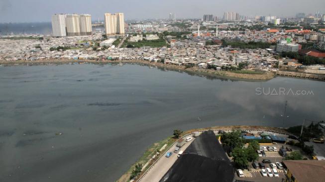 Suasana Waduk Pluit yang dipenuhi pemukiman padat penduduk di Jakarta Utara, Kamis (13/12). [Suara.com/Fakhri Hermansyah]