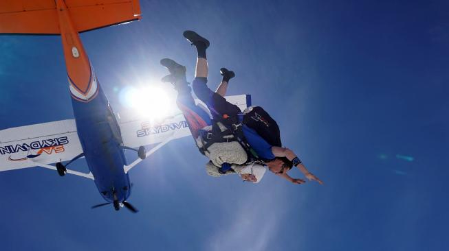 Nenek Irene O'shea saat melakukan aksi terjun payung di langit Australia Selatan, Minggu (9/12). [Bryce SELLICK, Matt TEAGER / SA Skydiving / AFP]
