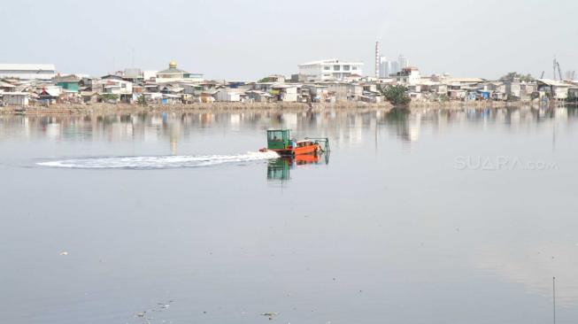 Suasana Waduk Pluit yang dipenuhi pemukiman padat penduduk di Jakarta Utara, Kamis (13/12). [Suara.com/Fakhri Hermansyah]