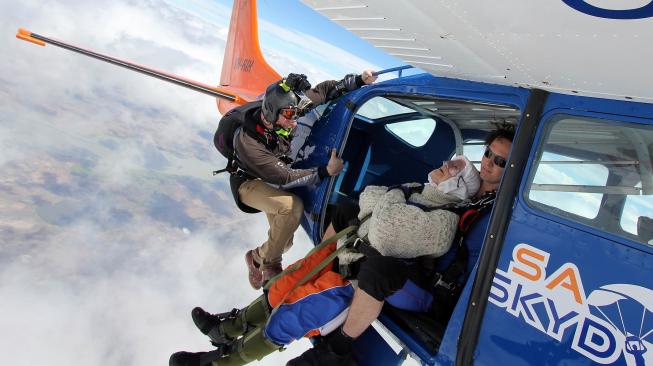 Nenek Irene O'shea saat melakukan aksi terjun payung di langit Australia Selatan, Minggu (9/12). [Bryce SELLICK, Matt TEAGER / SA Skydiving / AFP]
