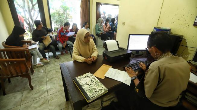 Sejumlah petugas kepolisian melayani warga untuk pengurusan SKCK di Kantor Polsek Ciracas, Jakarta, Jumat (14/12). [Suara.com/Muhaimin A Untung]