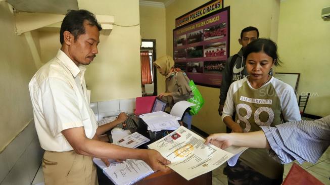 Sejumlah petugas kepolisian melayani warga untuk pengurusan SKCK di Kantor Polsek Ciracas, Jakarta, Jumat (14/12).[Suara.com/Muhaimin A Untung]