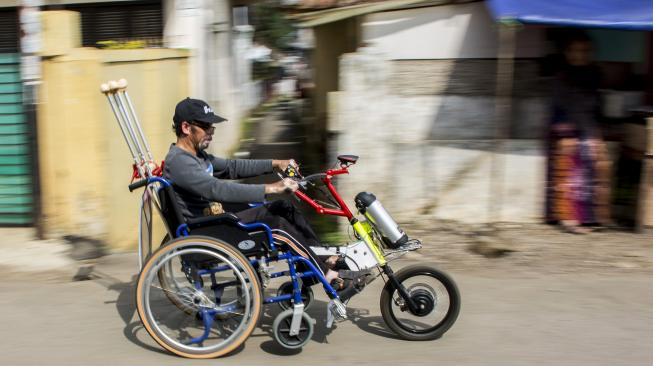 Iman Suwandi mencoba motor listrik penarik kursi roda di Kampung Inggris, Sukaraja, Kabupaten Sukabumi, Jawa Barat, Kamis (13/12). [ANTARA FOTO/Nurul Ramadha]