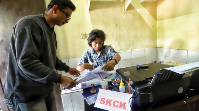 Sejumlah petugas kepolisian melayani warga untuk pengurusan SKCK di Kantor Polsek Ciracas, Jakarta, Jumat (14/12).[Suara.com/Muhaimin A Untung]