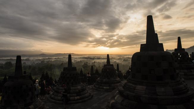 Wisatawan menikmati suasana matahari terbit di kawasan Taman Wisata Candi (TWC) Borobudur, Magelang, Jawa Tengah, Sabtu (15/12).  [ANTARA FOTO/M Agung Rajasa]