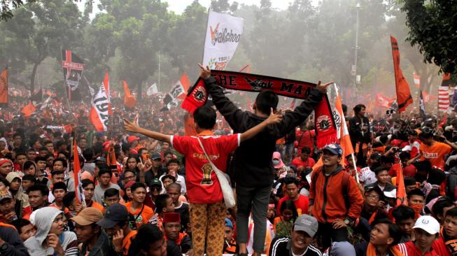 The Jak Mania memenuhi jalan depan Gedung Balai Kota usai pawai kemenangan di Jakarta Pusat, Sabtu (15/12). [Suara.com/Fakhri Hermansyah]