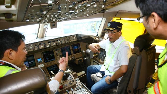 Menteri Perhubungan Budi Karya Sumadi (tengah) mendengarkan penjelasan dari Kapten Pilot Garuda Indonesia saat melakukan sidak kesiapan angkutan Natal dan Tahun Baru di Bandara Soekarno Hatta, Tangerang, Banten, Sabtu (15/12). [ANTARA FOTO/Muhammad Iqba]
