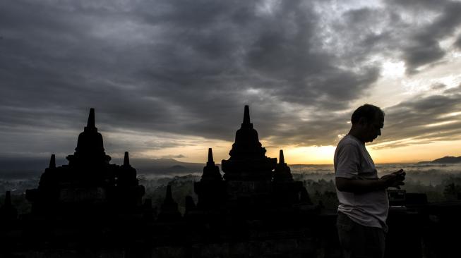 Wisatawan menikmati suasana matahari terbit di kawasan Taman Wisata Candi (TWC) Borobudur, Magelang, Jawa Tengah, Sabtu (15/12).  [ANTARA FOTO/M Agung Rajasa]