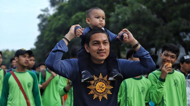 Sejumlah peserta mengikuti jalan santai keluarga besar Muhammadiyah DKI jakarta di Silang Barat Daya Monas, Jakarta, Minggu (16/12). [Suara.com/Muhaimin A Untung]